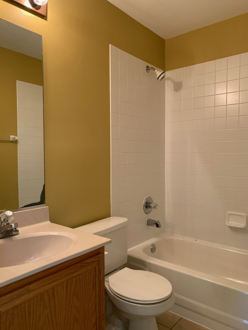 703 Riding Lane, Unit 703 St. Charles, IL 60174 - Photo 19 of 22 a bathroom with a granite countertop sink toilet and shower