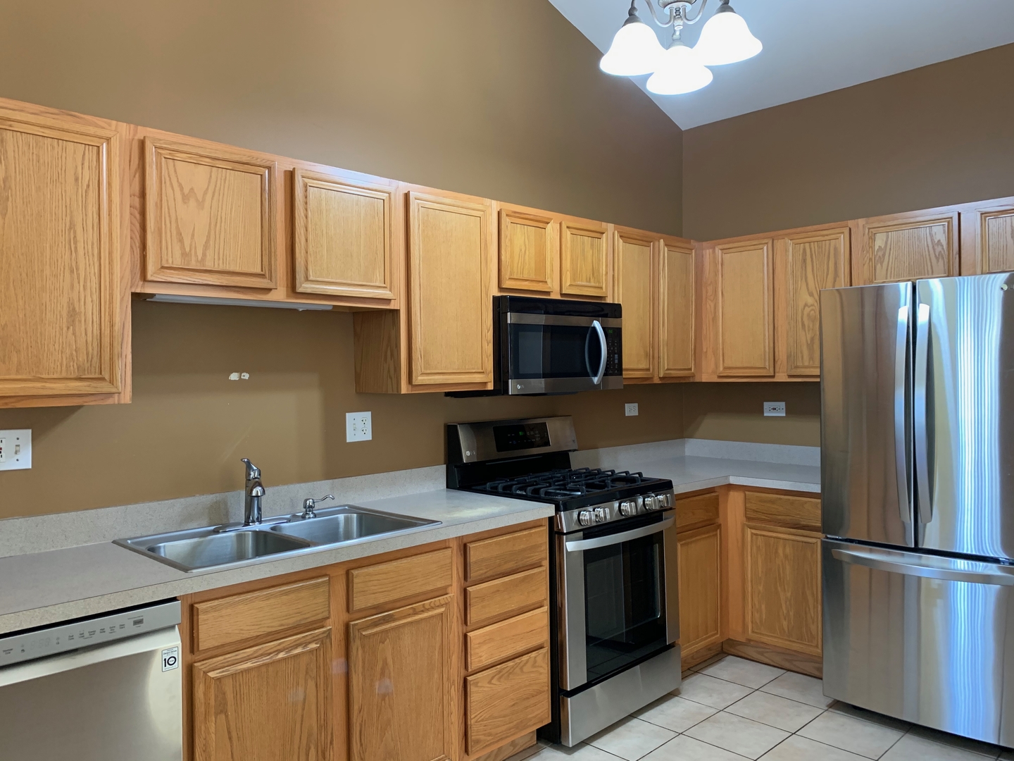 703 Riding Lane, Unit 703 St. Charles, IL 60174 - Photo 10 of 22 a kitchen with granite countertop white cabinets and stainless steel appliances