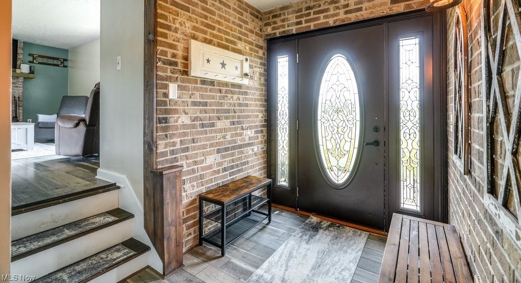 81 Bolender Road Mogadore, OH 44260 - Photo 3 of 35 Wood floored entrance foyer with brick wall, plenty of natural light