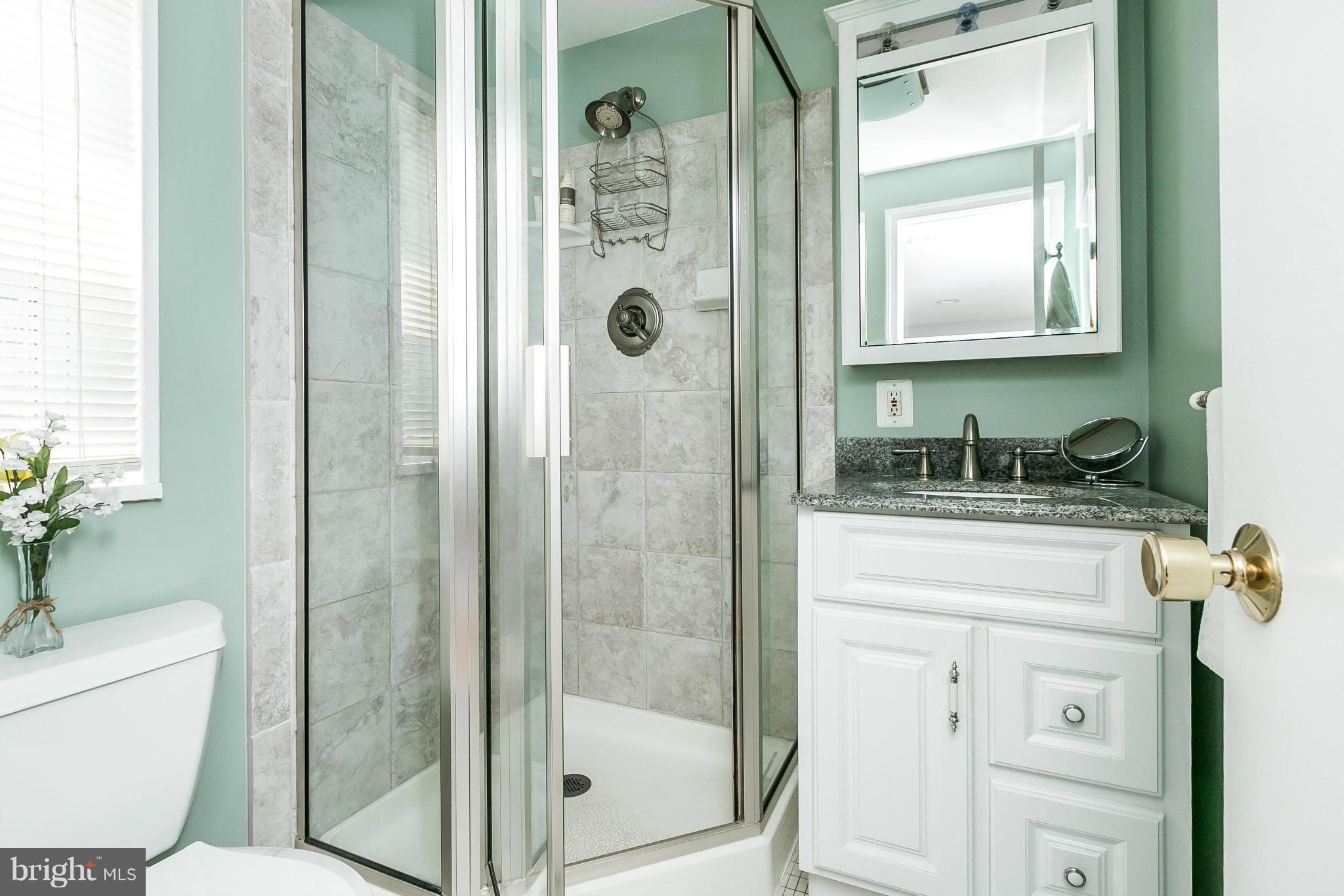 1901 Logwind Road Catonsville, MD 21228 - Photo 13 of 30 a bathroom with a granite countertop sink a toilet and shower