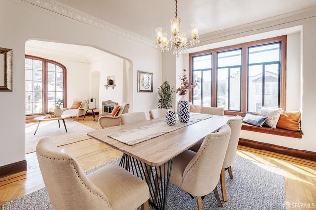 a view of a dining room with furniture a chandelier and wooden floor