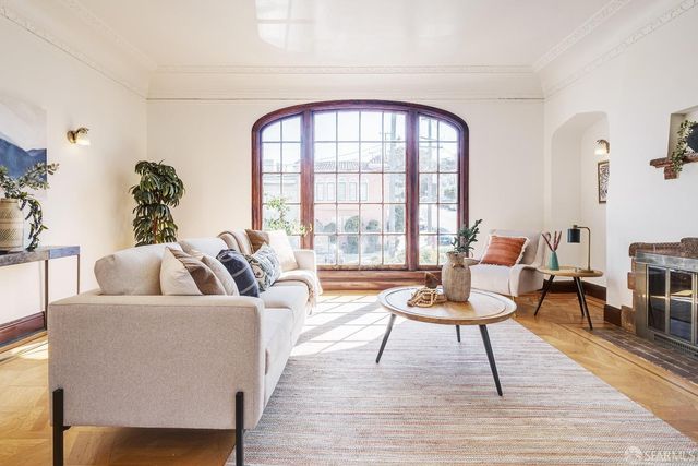 a living room with furniture a table and a large window