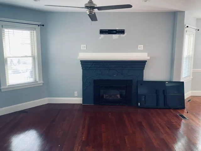 an empty room with a fireplace and wooden floor