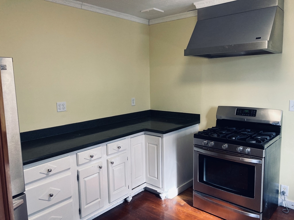 42 Alicia Road, Unit 1 Boston, MA 02124 - Photo 16 of 19 a kitchen with granite countertop white cabinets and black appliances