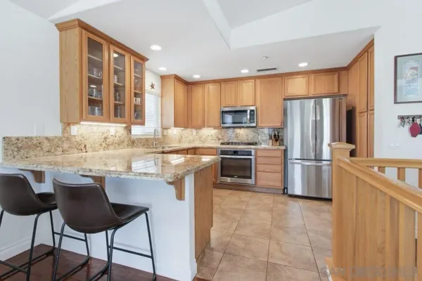 a kitchen with kitchen island granite countertop a stove refrigerator and cabinets