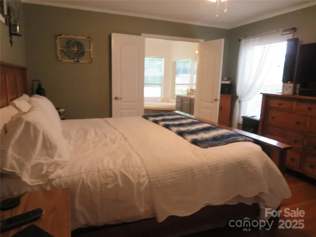 a bedroom with a bed and a flat screen tv