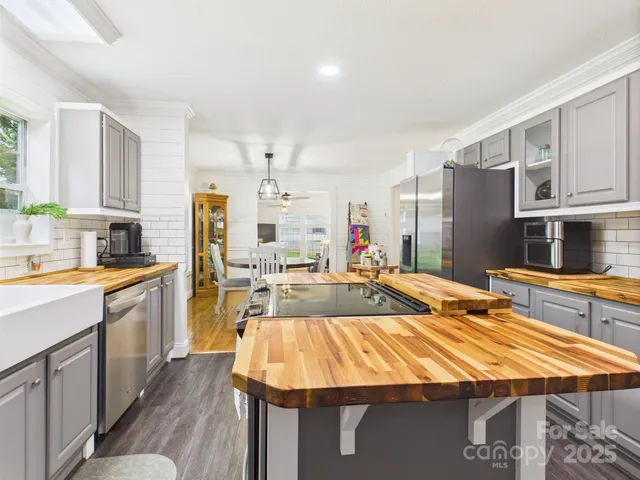 a kitchen with kitchen island granite countertop lots of counter top space and stainless steel appliances