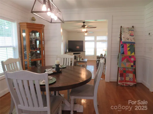a dining room with furniture a chandelier and wooden floor