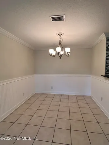 a view of a room with a chandelier fan and glass door