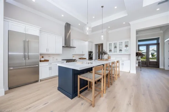 a kitchen with kitchen island a counter top space a sink stainless steel appliances and cabinets
