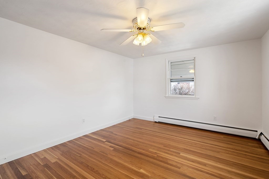 21 Desoto Road Boston, MA 02132 - Photo 21 of 37 an empty room with wooden floor and fan