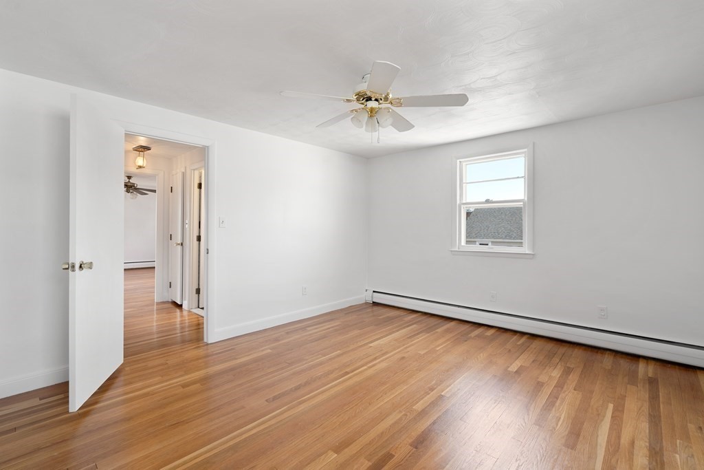21 Desoto Road Boston, MA 02132 - Photo 24 of 37 an empty room with wooden floor chandelier fan and windows