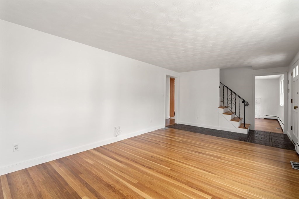 21 Desoto Road Boston, MA 02132 - Photo 7 of 37 a view of an empty room with wooden floor and stairs