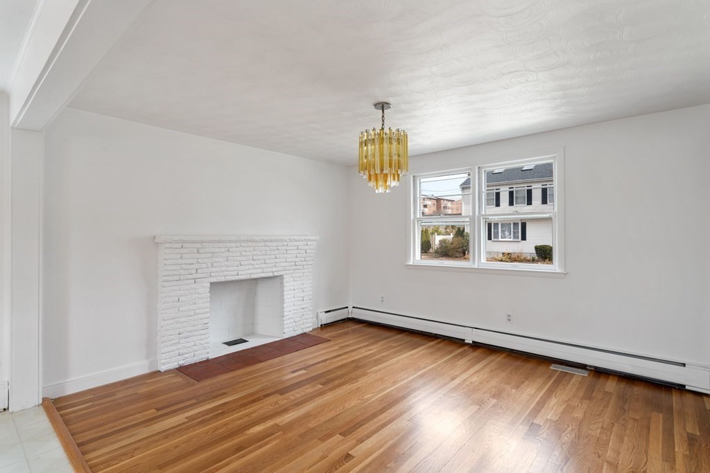 21 Desoto Road Boston, MA 02132 - Photo 9 of 37 a view of empty room with wooden floor and fireplace