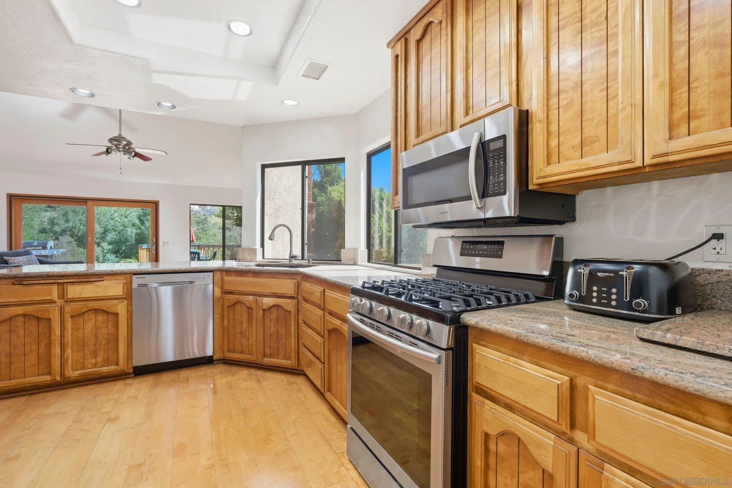 15927 Litten Way Ramona, CA 92065 - Photo 7 of 33 a kitchen with stainless steel appliances granite countertop a stove a sink and a microwave