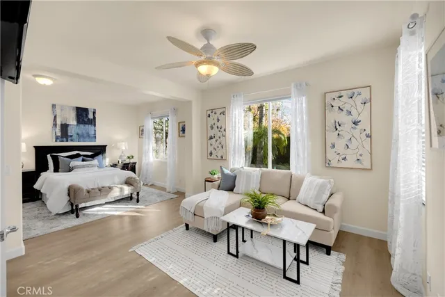 a spacious bedroom with a bed a couch and a chandelier