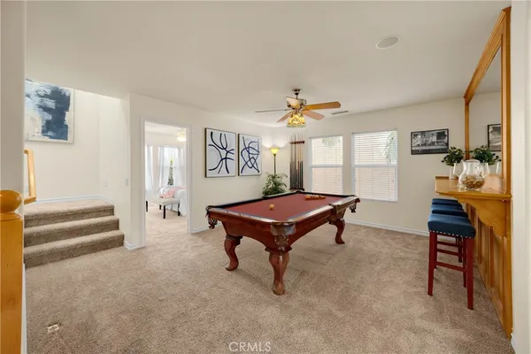 a room with furniture pool table and windows