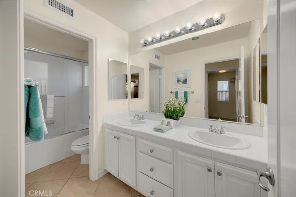 a bathroom with a double vanity sink toilet and shower