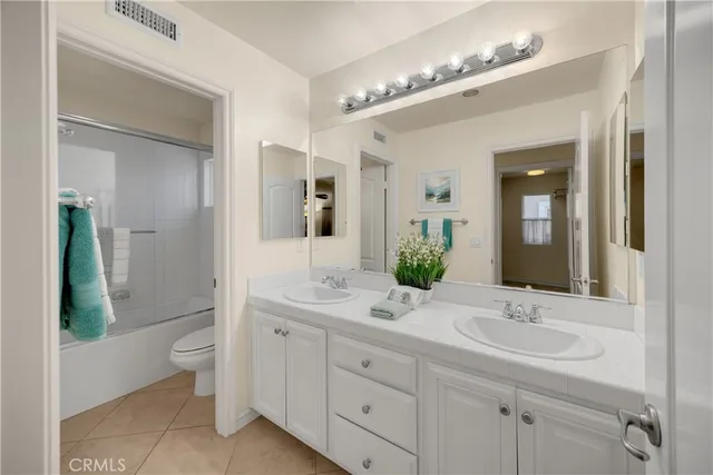 a bathroom with a double vanity sink toilet and shower
