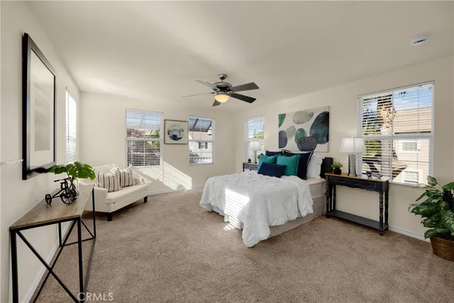 a spacious bedroom with a bed couch and windows