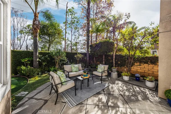 a view of backyard with outdoor seating a patio and plants