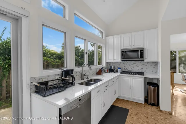 a kitchen with a sink stove top oven and cabinets
