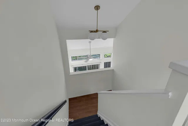 a view of a room with a wooden floor and white wall