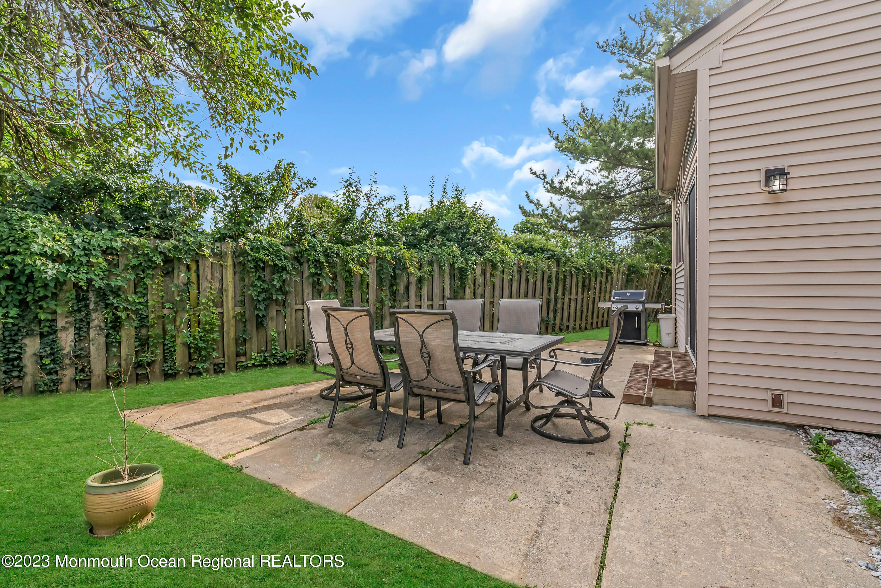 700 Ocean Avenue, Unit 9 Long Branch, NJ 07740 - Photo 33 of 35 a view of a patio with table and chairs potted plants and large tree