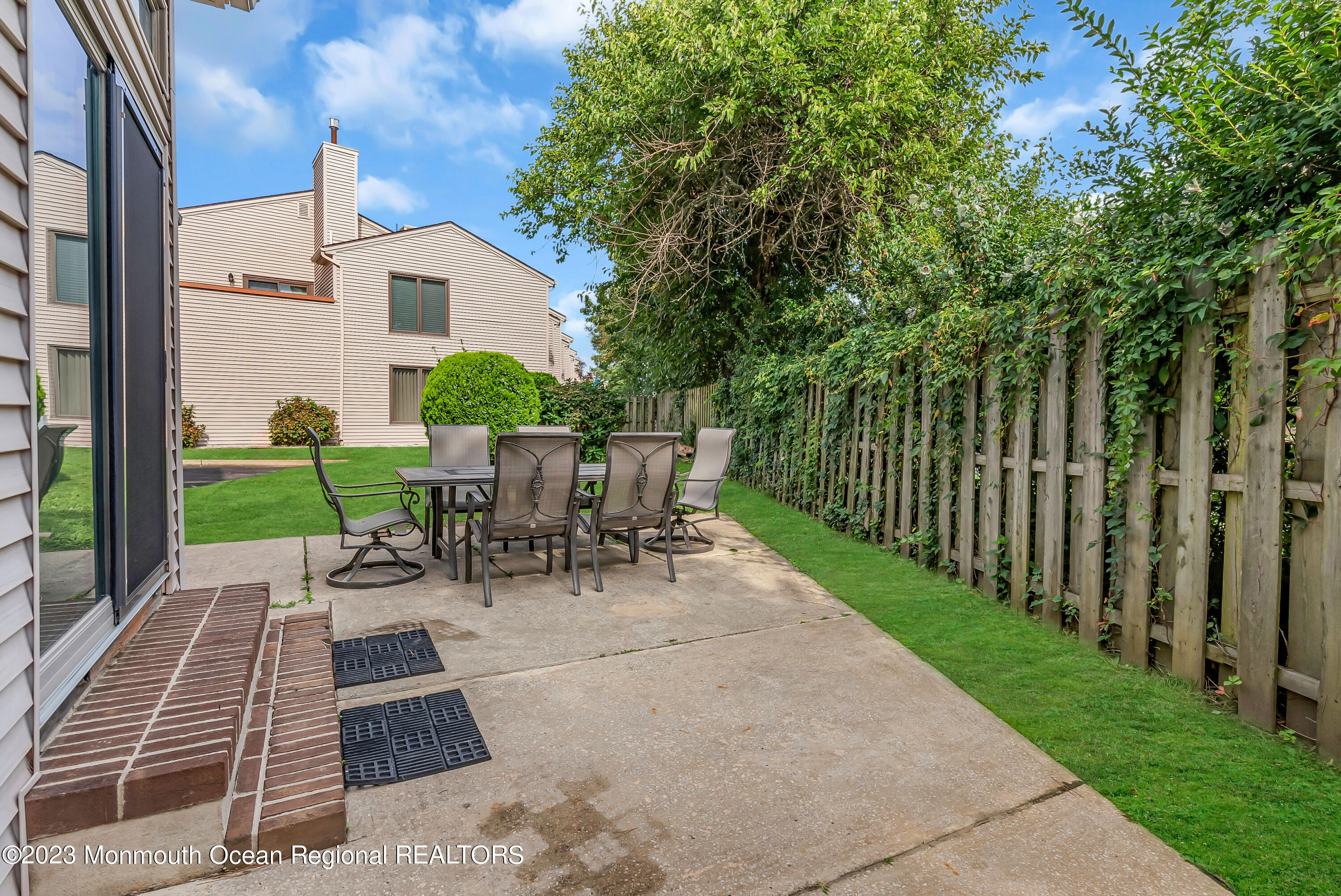 700 Ocean Avenue, Unit 9 Long Branch, NJ 07740 - Photo 34 of 35 a view of a patio with a dining table and chairs with wooden fence