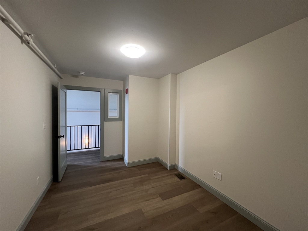 160 Seabury Street, Unit 30 Fall River, MA 02720 - Photo 11 of 13 an empty room with wooden floor and windows