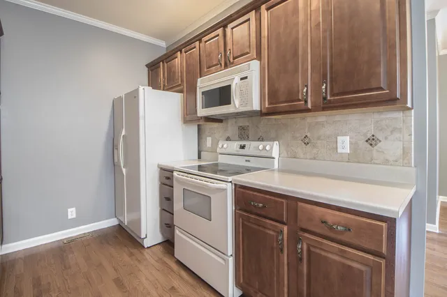 a kitchen with stainless steel appliances granite countertop a refrigerator and a stove top oven