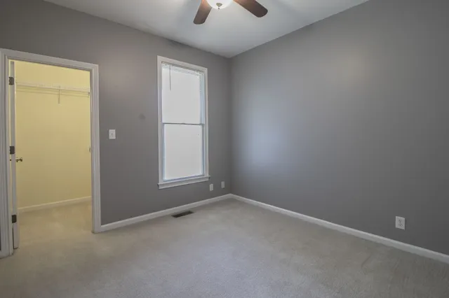 an empty room with chandelier fan
