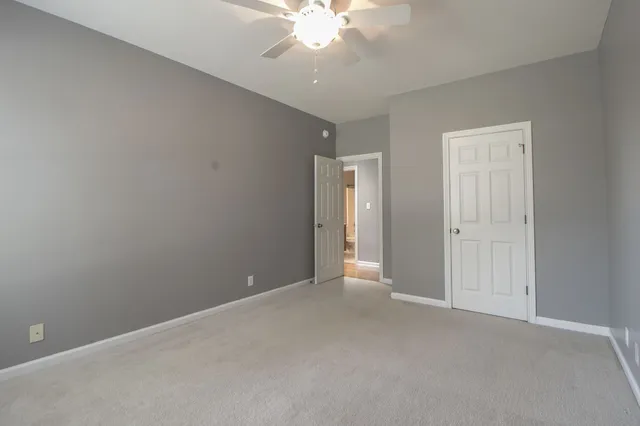 an empty room with a ceiling fan and a window