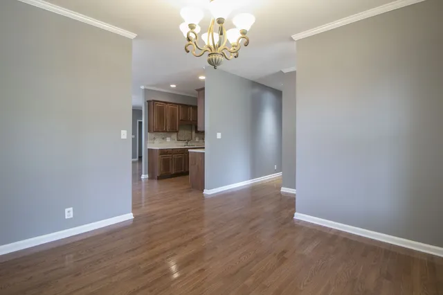 a view of a kitchen with wooden floor and a chandelier