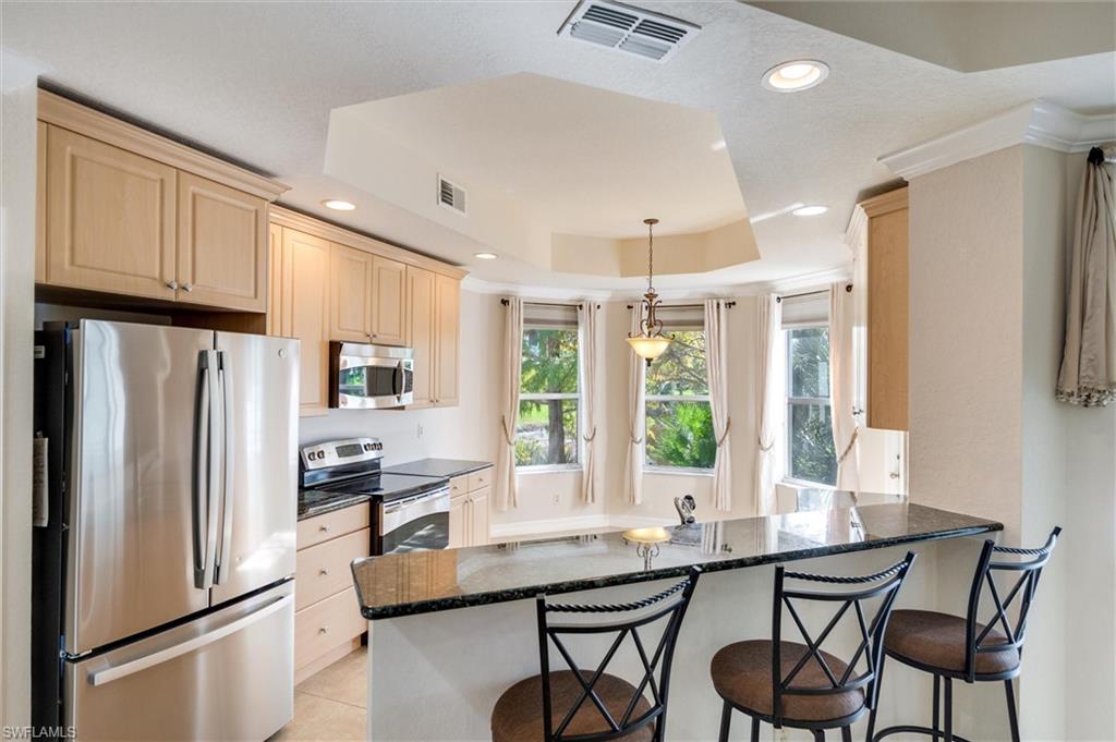 3600 Lansing Loop, Unit 103 Estero, FL 33928 - Photo 13 of 33 a kitchen with stainless steel appliances a refrigerator a sink and a stove with white cabinets