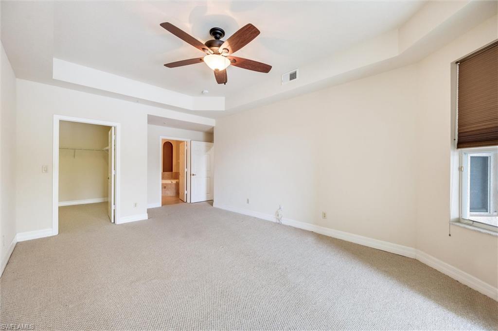 3600 Lansing Loop, Unit 103 Estero, FL 33928 - Photo 21 of 33 an empty room with chandelier fan and windows