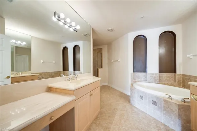 a bathroom with a tub sink and mirror