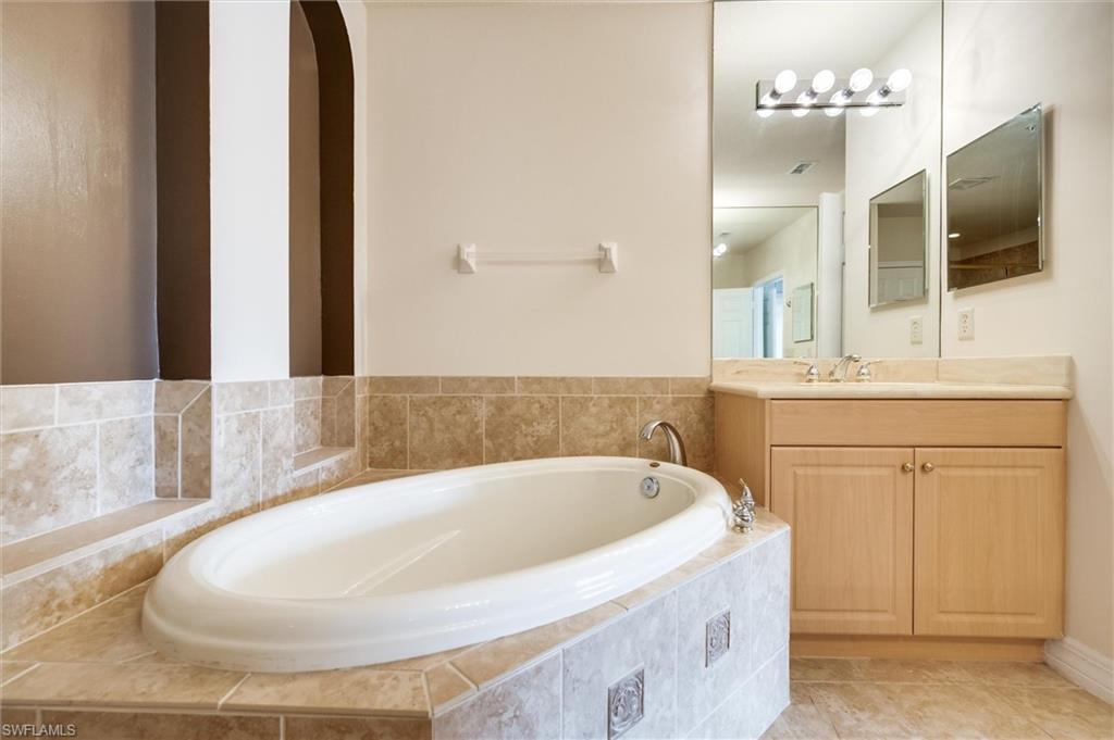 3600 Lansing Loop, Unit 103 Estero, FL 33928 - Photo 23 of 33 a bathroom with a tub sink and mirror
