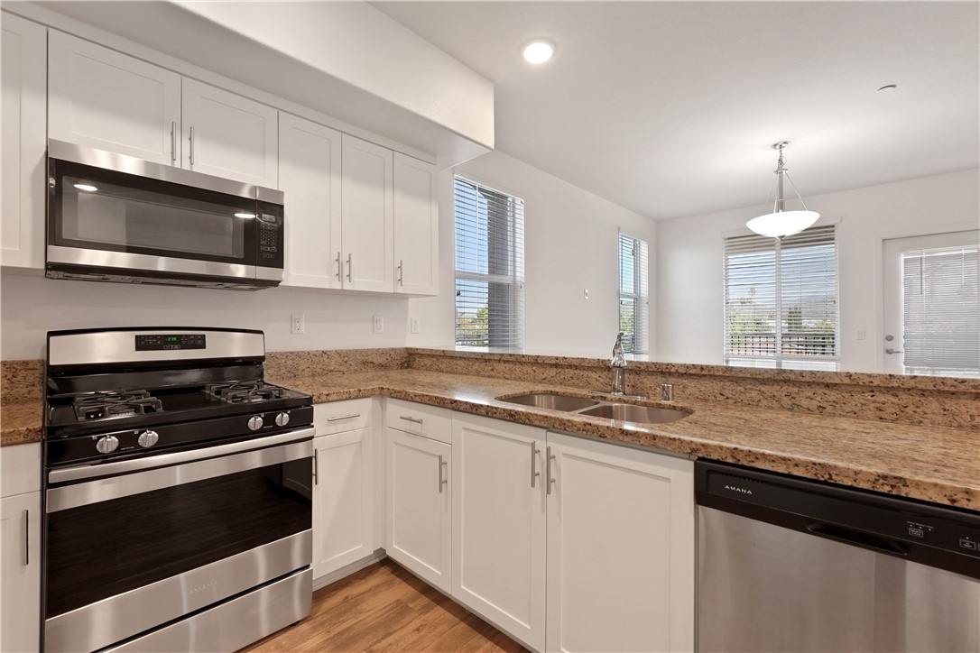 a kitchen with stainless steel appliances granite countertop a stove and a microwave