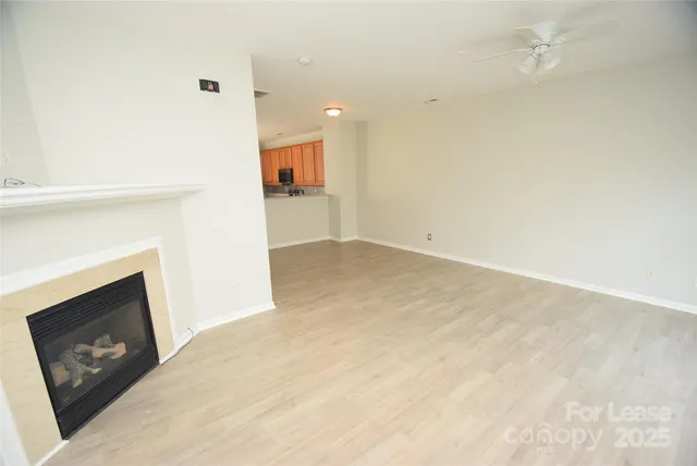 an empty room with wooden floor and fireplace