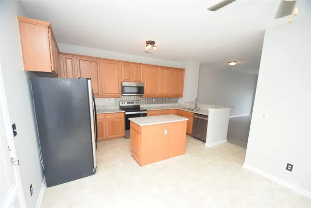a kitchen with a refrigerator and a stove
