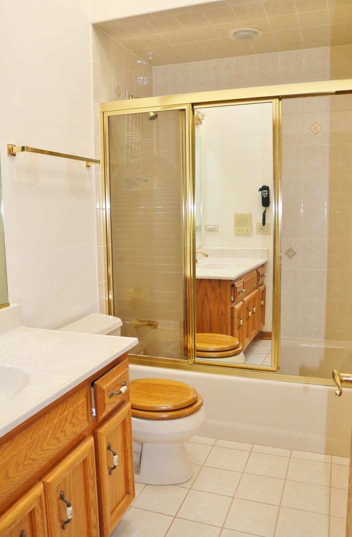 12232 Grove Road Minooka, IL 60447 - Photo 40 of 57 a bathroom with a granite countertop sink a toilet and shower