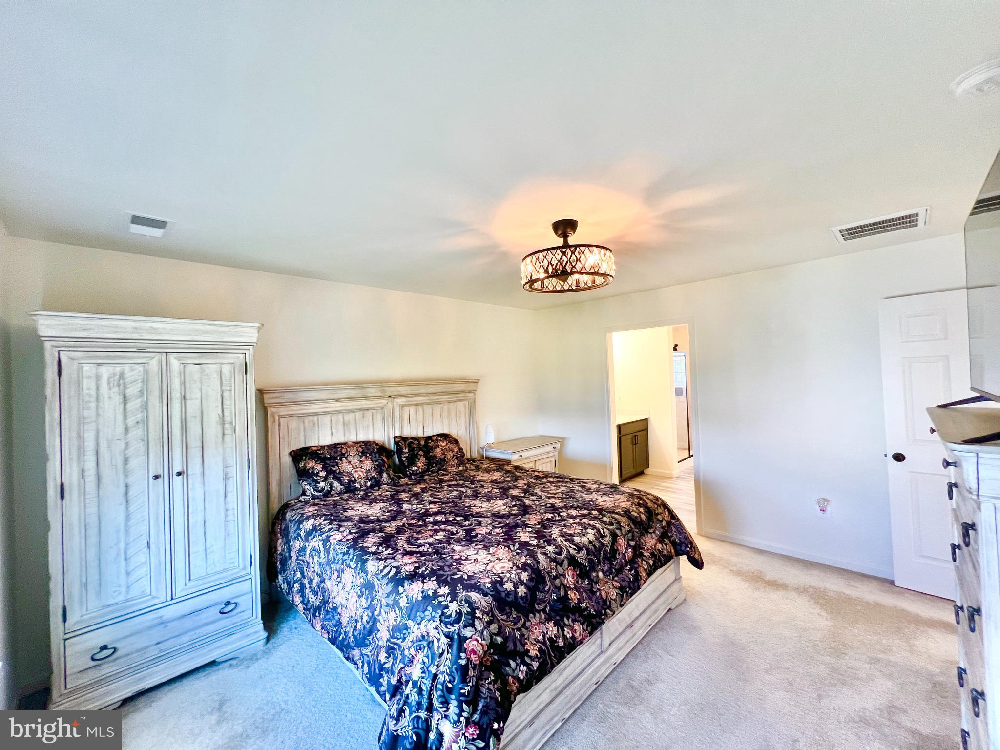 6366 Pointer Lane King George, VA 22485 - Photo 21 of 48 a bed sitting in a room next to a window and a chandelier