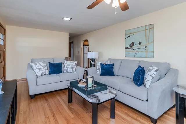 a living room with furniture and a wooden floor