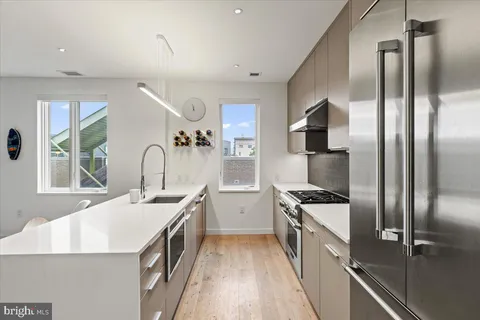 a view of kitchen with stainless steel appliances granite countertop a stove and a sink
