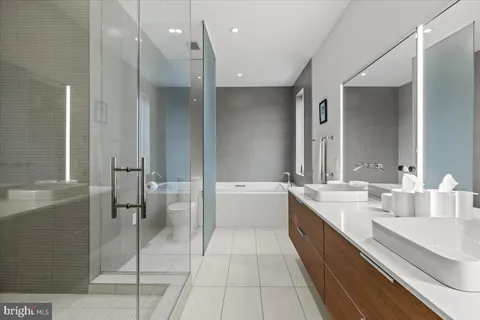 a bathroom with a double vanity sink mirror double and bathtub