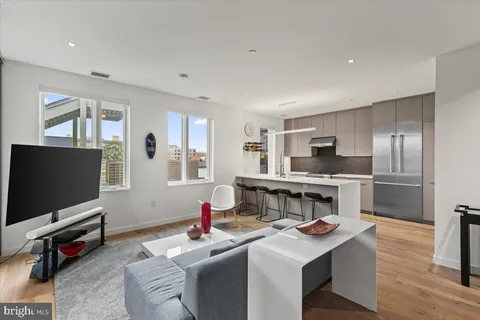 a kitchen with a refrigerator a sink and chairs