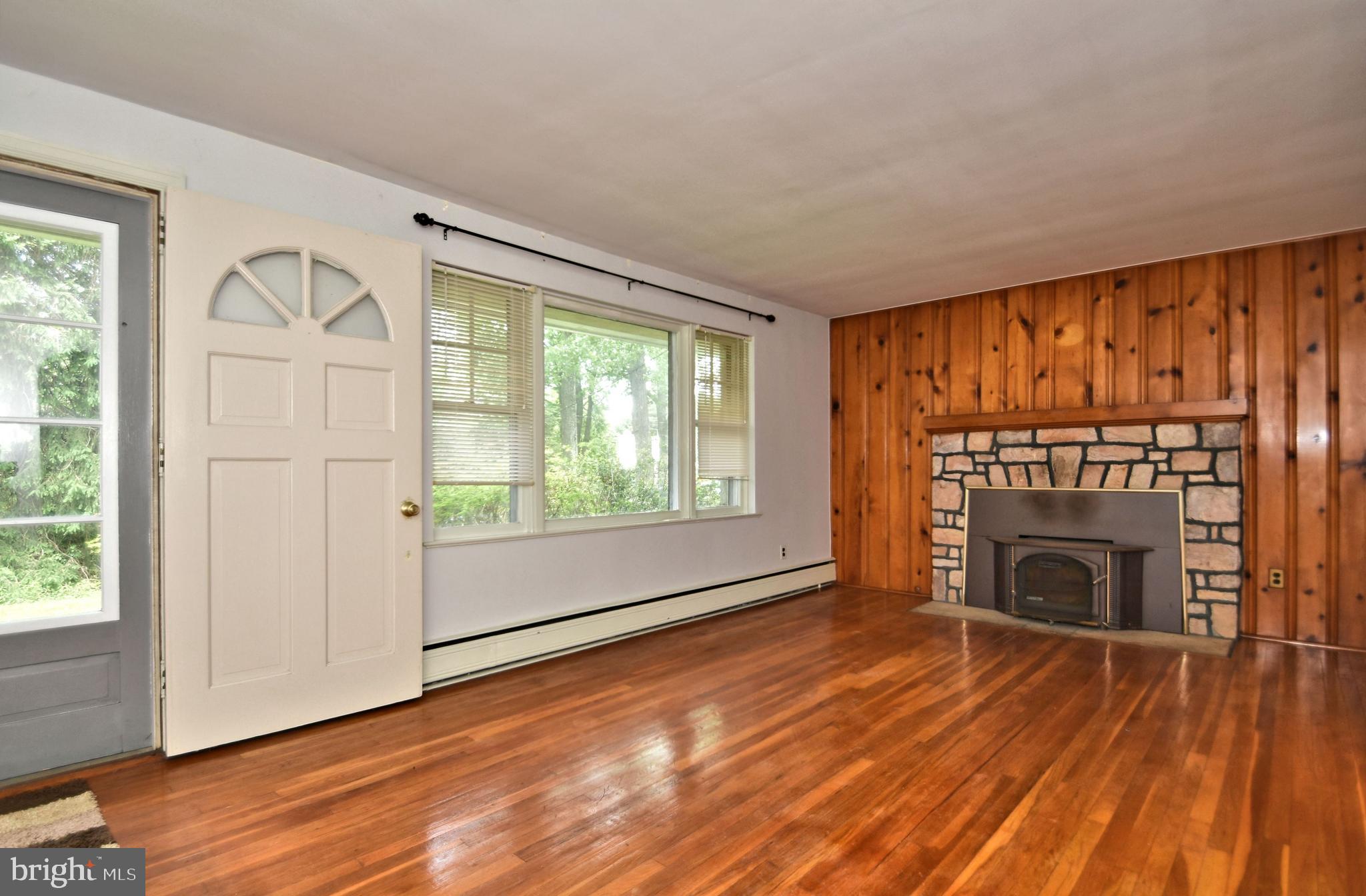 70 Old State Road Devon, PA 19333 - Photo 3 of 20 an empty room with wooden floor fireplace and windows