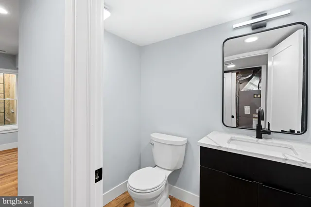 a bathroom with a toilet a sink a mirror and vanity