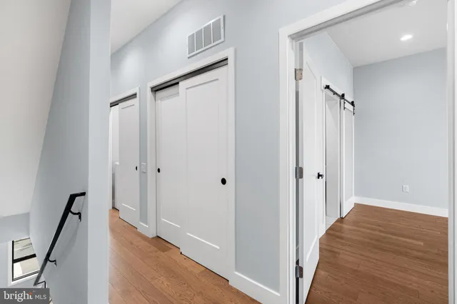 a view of a hallway with wooden floor and staircase